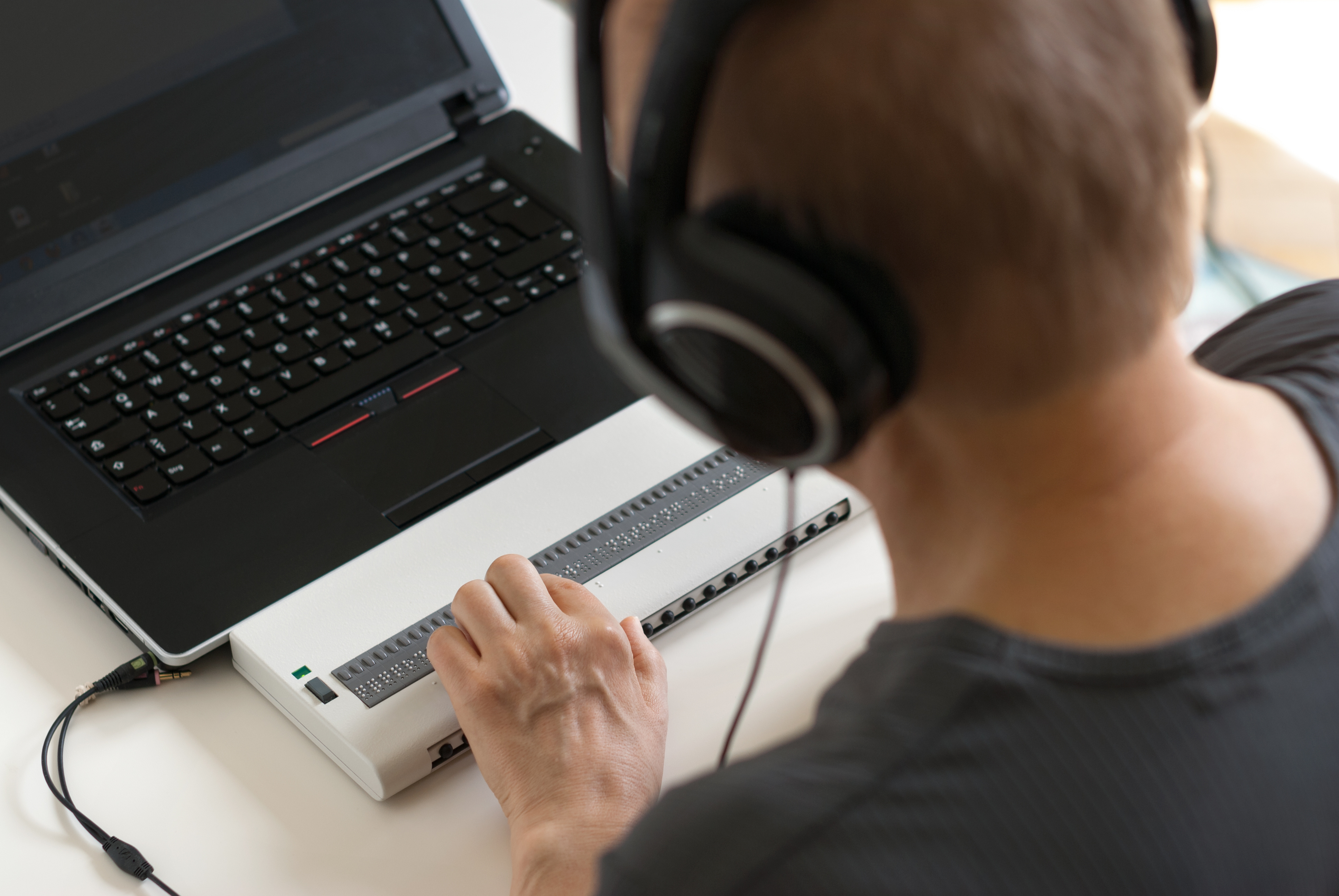 Vision impaired user uses a braille computer keyboard.