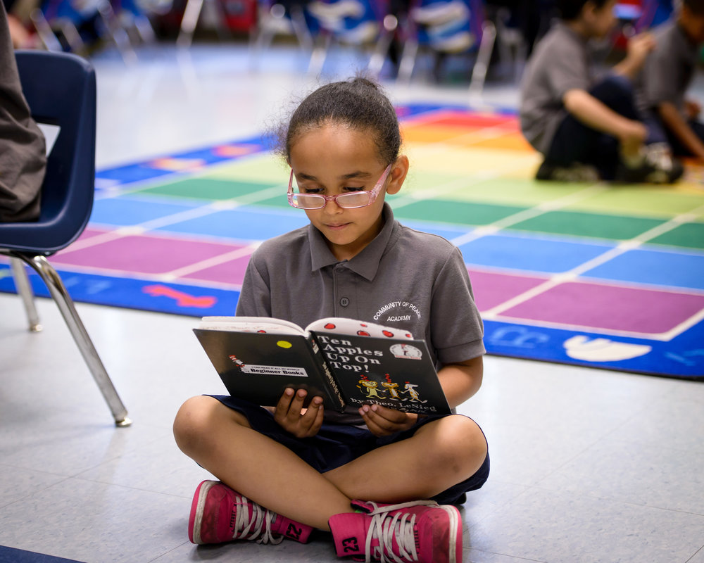 a girl sitting down and reading a book