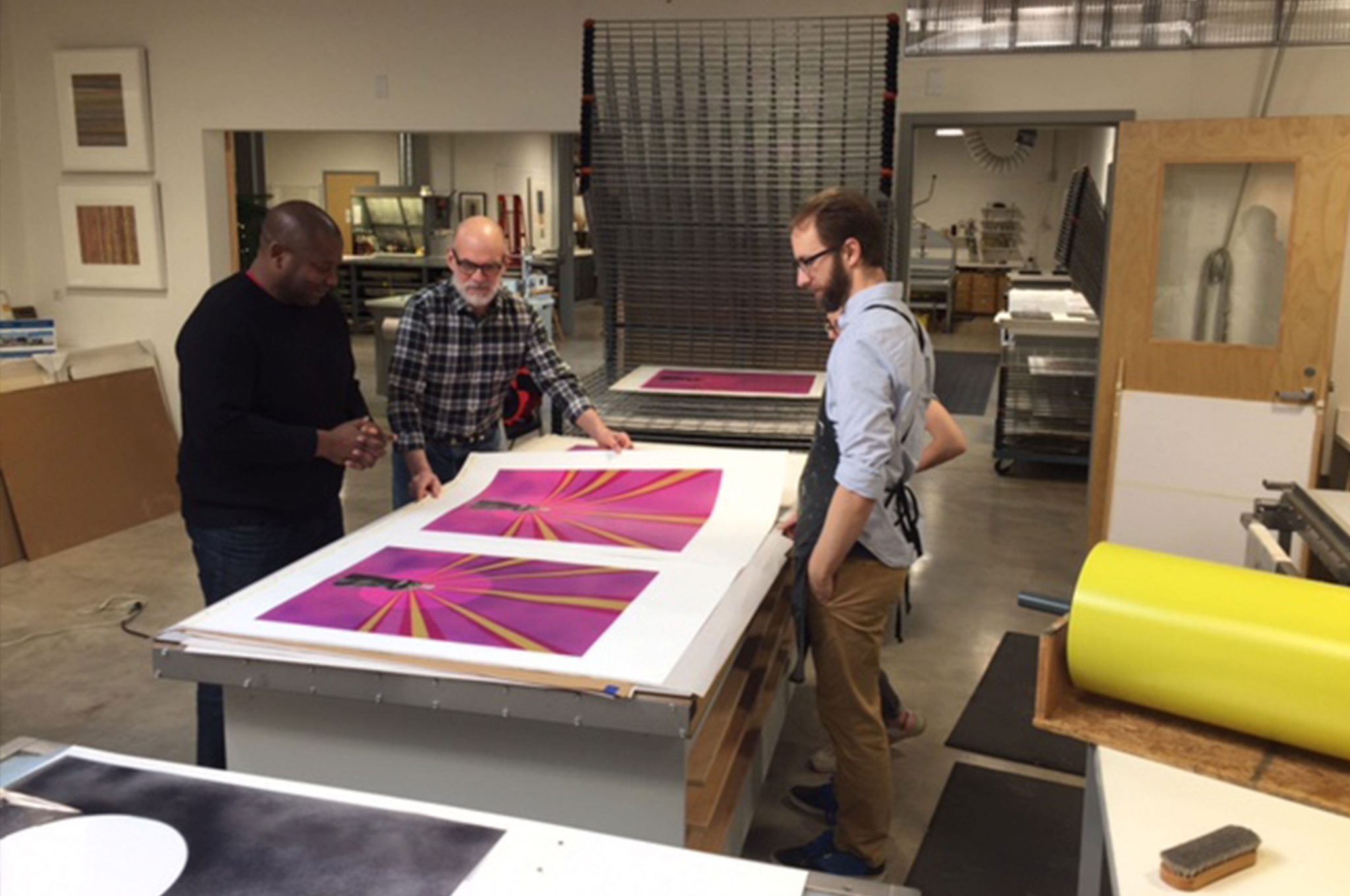 Visiting artist Rico Gatson, Cole Rogers, a master printer, and Zac Adams-Bliss, a senior printer, review printer proofs at Highpoint.