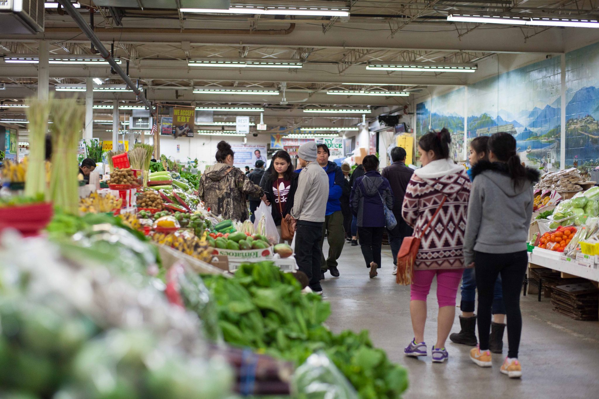 People shopping in an indoor farmers market.