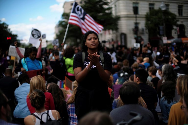 A Woman Applauds As Protesters Kneel On One Knee Outside The Trump International Hotel On Pennsylvania Avenue During The March For Racial Justice Calling For Racial Equity And Justice In Washington