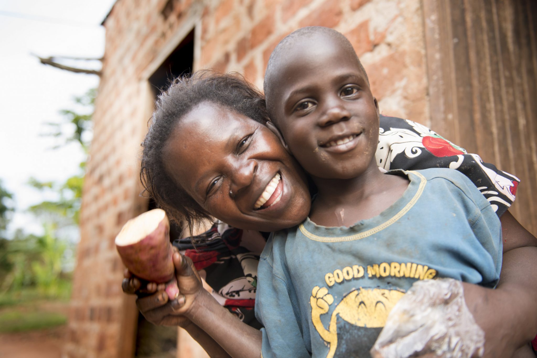 a mother and her son holding a vegetable while smiling and posing for a picture