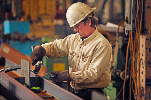 a man with a helmet hamering wires down