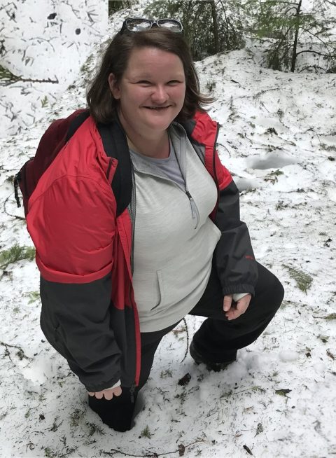 Sarah up to her knees in the snow at Glacier National Park