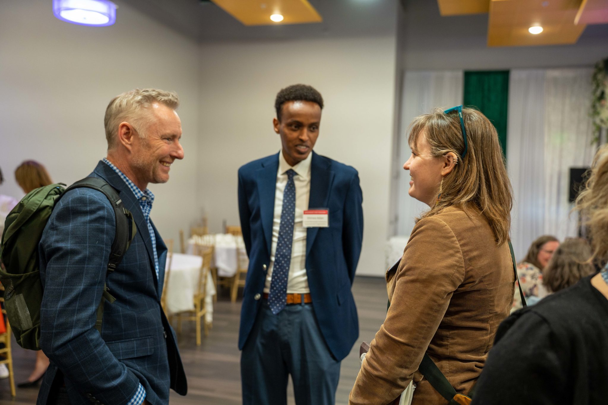 Sawirka, bidix ilaa midig: Chad Schwitters, sarkaalka barnaamijka bulshada firfircoon iyo sinaanta; Shirwac Aadan, agaasimaha fulinta ee Ururka Xoojinta Bulshada ee Bartamaha Minnesota; Nora Hertel, aasaasaha deeq-bixiyaha McKnight Project Optimist. Central Minnesota Community Empowerment Organisation waxay taageertaa oo ay awood siisaa qaxootiga iyo jaaliyadaha soogalootiga ee Bartamaha Minnesota adeeg iyo u doodid. Project Optimist waxa uu ka hawl galaa dadka degan Minnesota weyn si ay isaga kaashadaan qaybaha kala qaybsanaantooda iyada oo loo marayo sheekooyinka diirada saaraya xalinta iyo farshaxanka deegaanka.