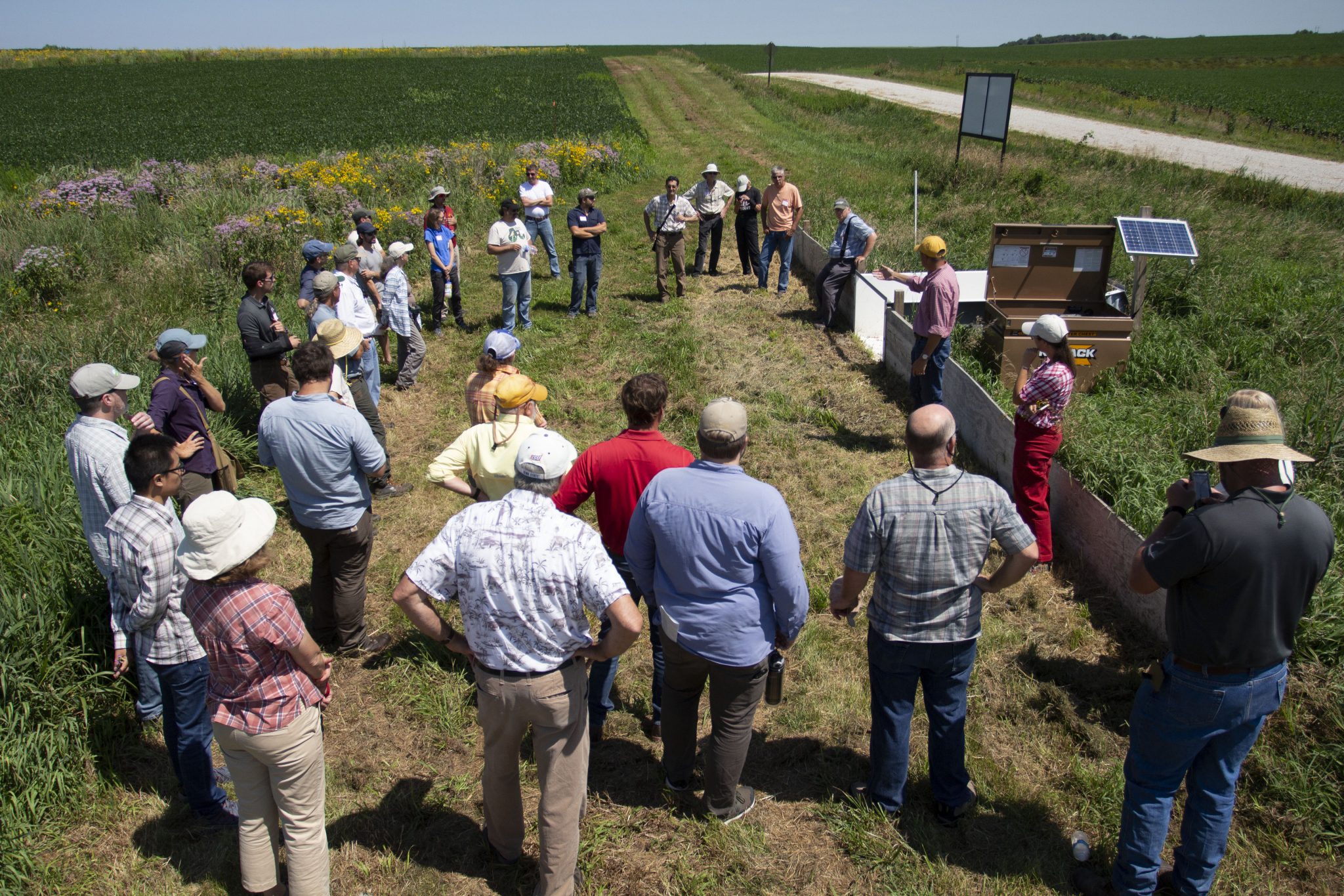 Farmers, land owners, scientists, and extension specialists gather to discuss research and implementation of prairie strips on commercial farms at Iowa State University Armstrong Memorial Research and Demonstration Farm, Lewis, Iowa. Prairie strips reduce soil and nutrient loss from corn and soybean farms while also supporting more diverse and abundant wildlife.