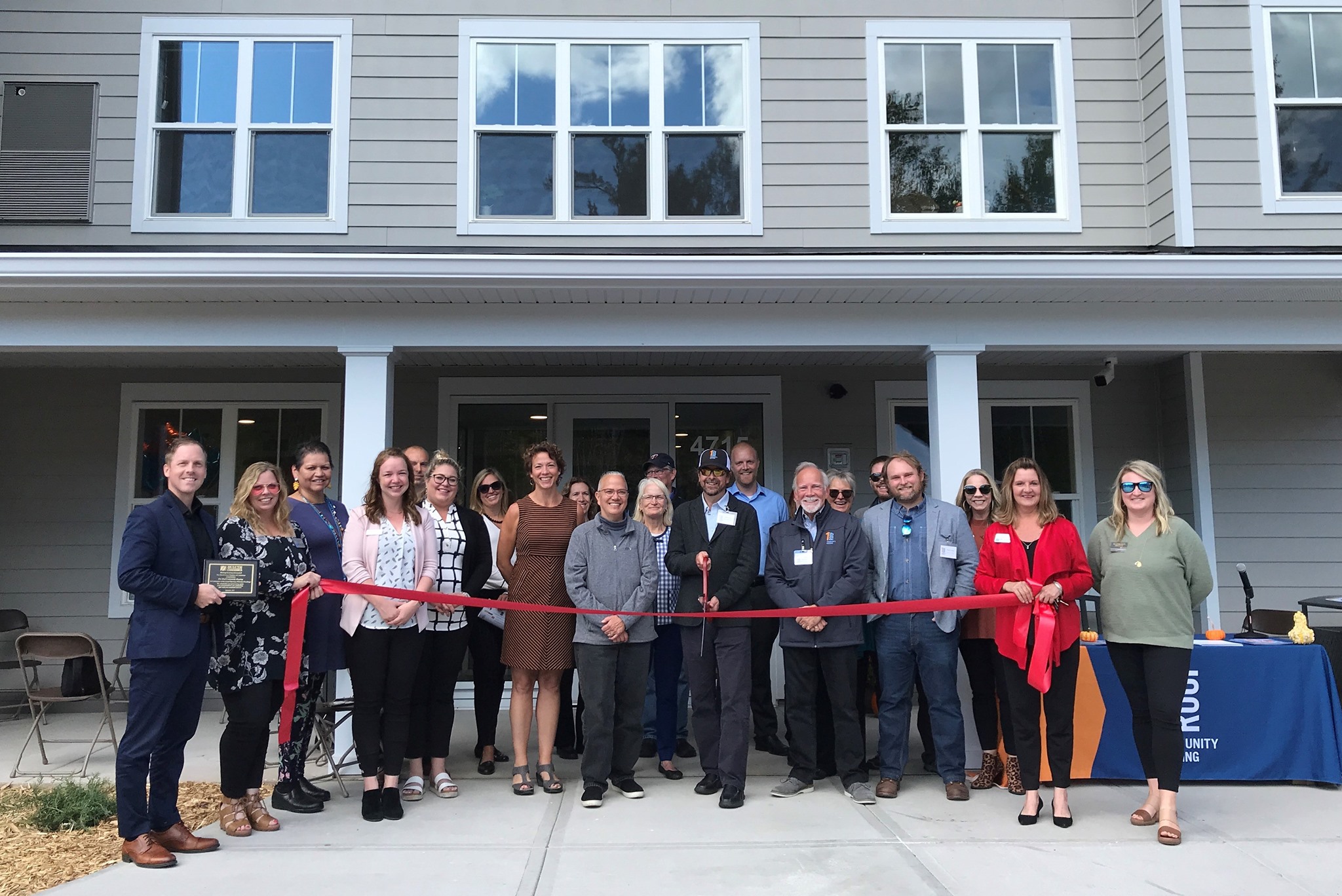 Jeff Corey prepares to cut the ribbon at the grand opening of Decker Dwellings, a 42-unit apartment building in Duluth. Photo credit: One Roof Community Housing