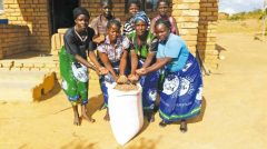 group of African women posing for a picture with their crops