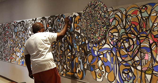 an African American man painting a wall