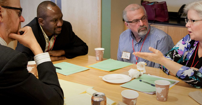 people sitting at a table discussing something