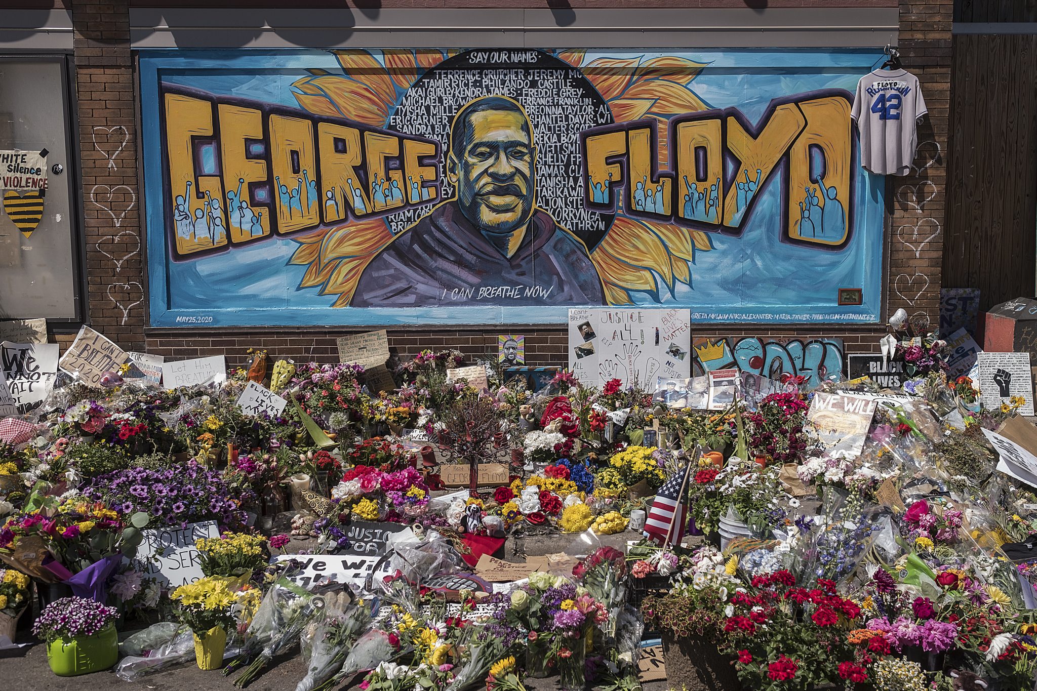A painting of George Floyd surrounded by flowers on the ground