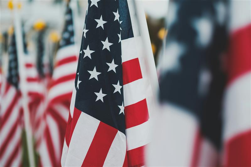 A close up of an American flag among a line of American flags