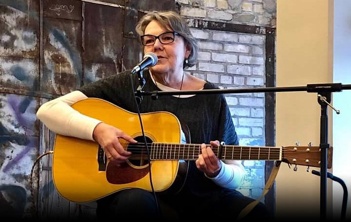 Vickie Benson plays guitar at a McKnight staff event.